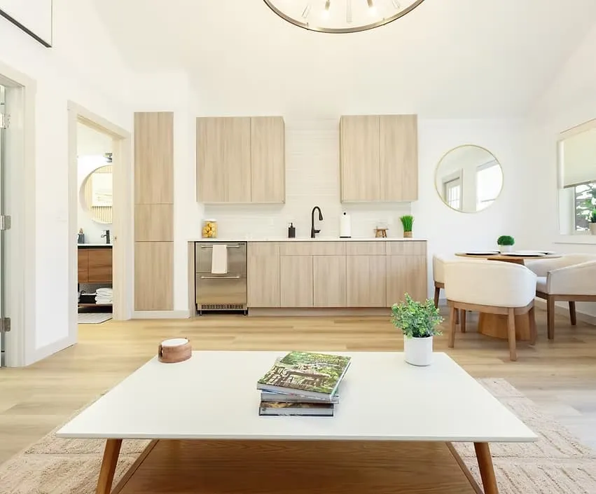 Bright cottage living room and kitchen with light wood cabinets