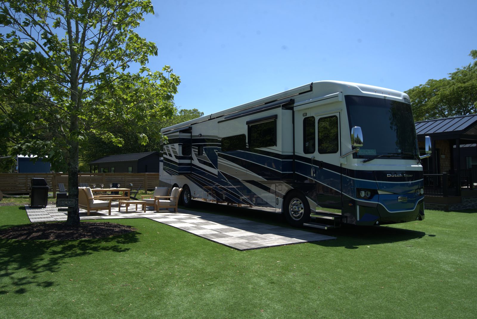 A motorhome on a landscaped Resort Lot at North Fork Resort with a patio and seating